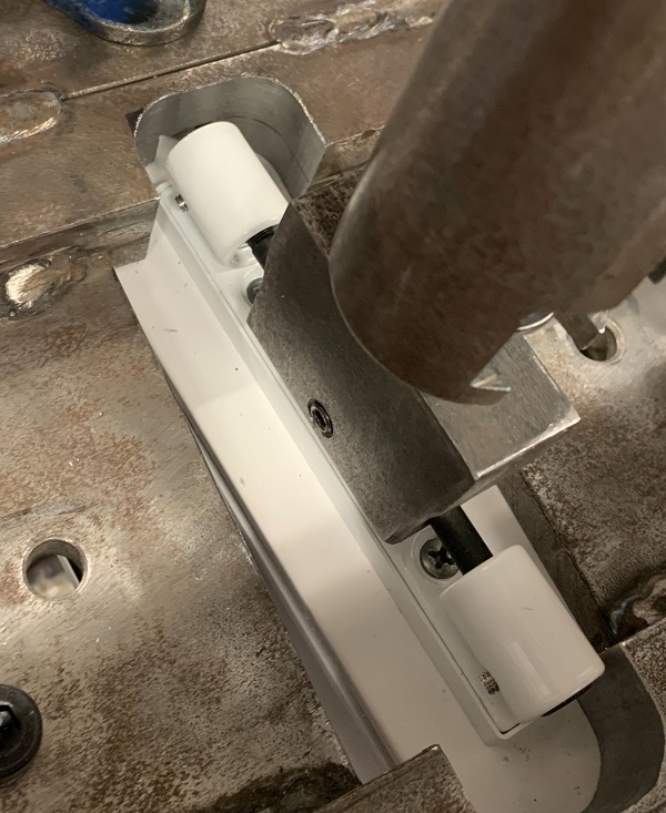 A PVC-U door hinge being tested for the strength of its attachment to an outer frame.